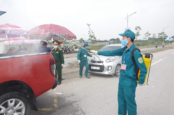 Lực lượng dân quân tự vệ khử trùng phương tiện tại chốt kiểm dịch.